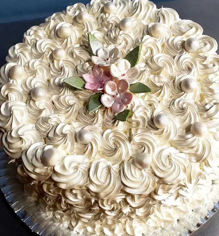 Bolo coberto de rosetas brancas com pérolas e flores