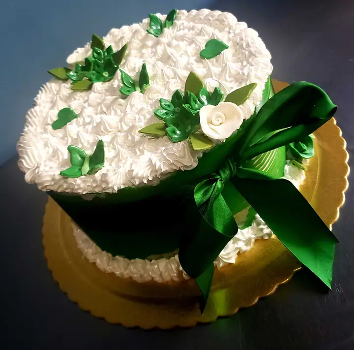 Bolo de rosetas brancas com folhas verdes e laço verde