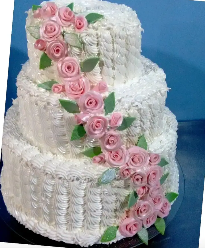 Bolo de três andares branco com cascata de rosas cor-de-rosa