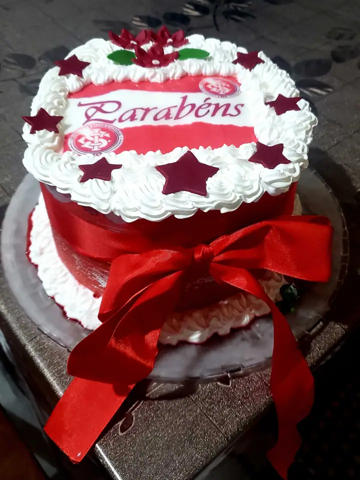 Bolo vermelho e branco com papel de arroz de parabéns e laço