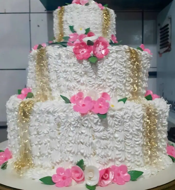 Bolo de andares branco com detalhes dourados e flores rosa