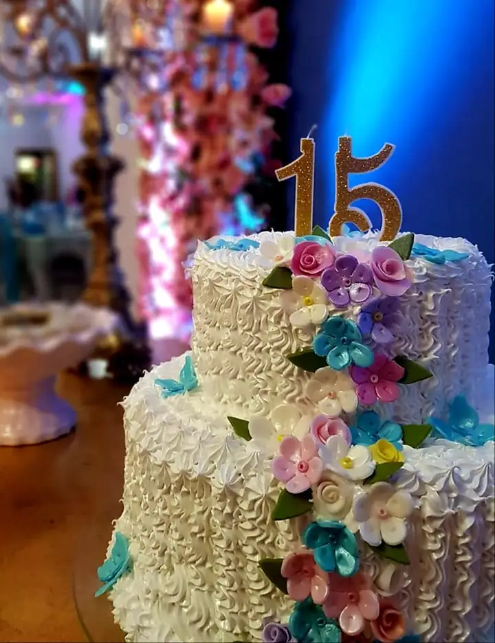 Bolo de 15 anos em dois andares com flores e topo dourado