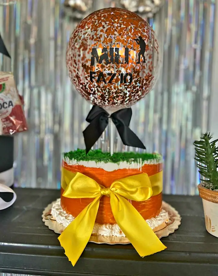 Bolo laranja com laço amarelo e balão personalizado