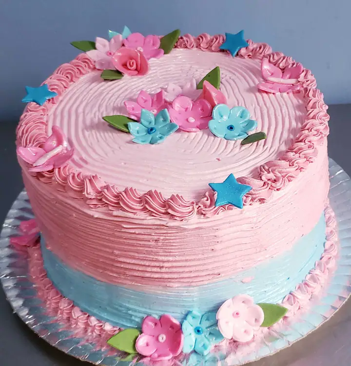 Bolo rosa e azul com flores e estrelas de açúcar