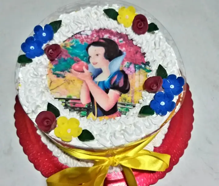 Bolo tema Branca de Neve com flores e laço amarelo
