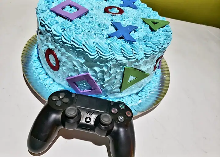 Bolo tema videogame azul com símbolos de controle